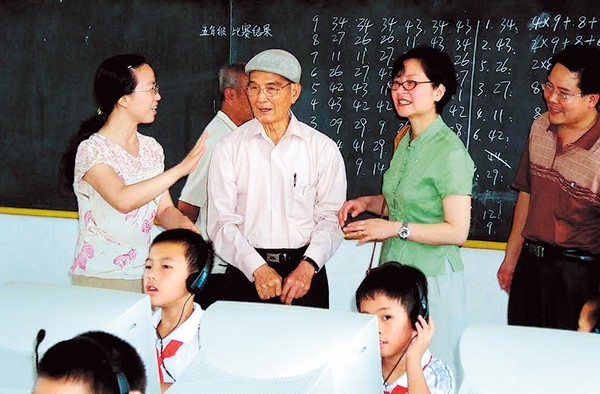 Lee Wah Yip (second from left) and Jeanette Kai Chan (third from left) visit Lantian Central Primary School in Dachong town, Zhongshan city, Guangdong province, in 2004. [Photo/China Daily]