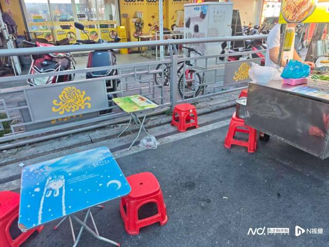 流动摊贩在机动车道上支桌椅。